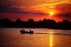 A boat on a lake at sunset.